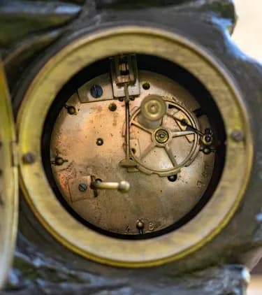 Three piece patinated metal clock set  Moreau 'Le Commerce'