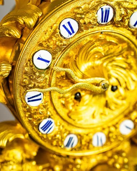 Fire-gilded three-piece clock set with rococo-style cherub and satyr depictions